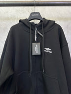 Balenciaga black zip-up hoodie with hood, central zipper, and chest logo label.