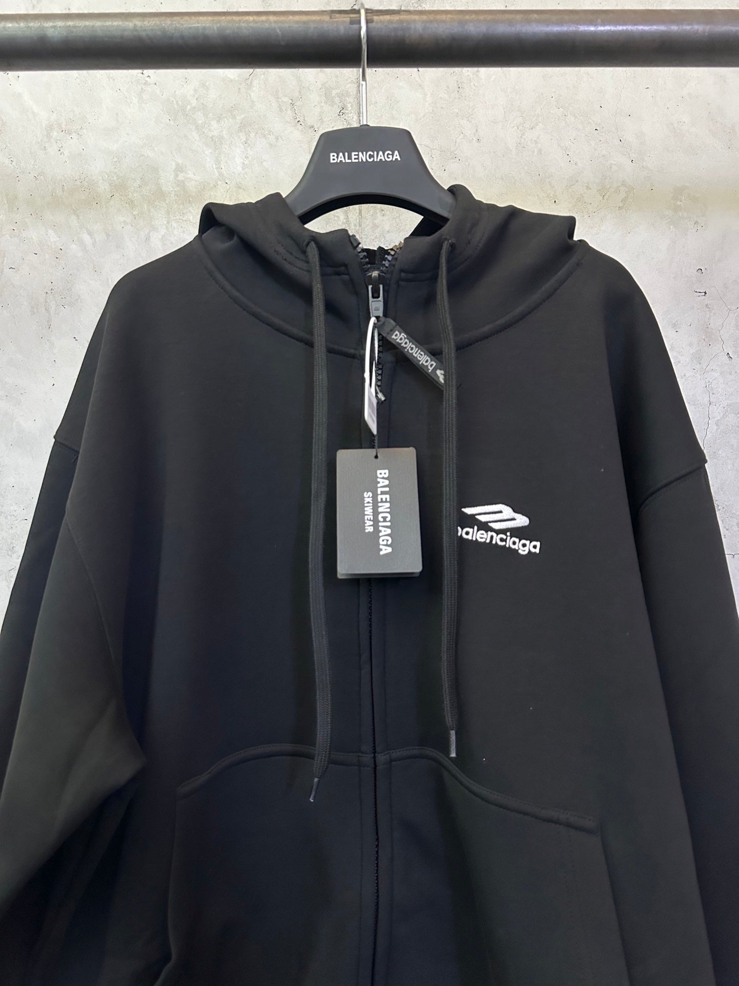 Balenciaga black zip-up hoodie with hood, central zipper, and chest logo label.
