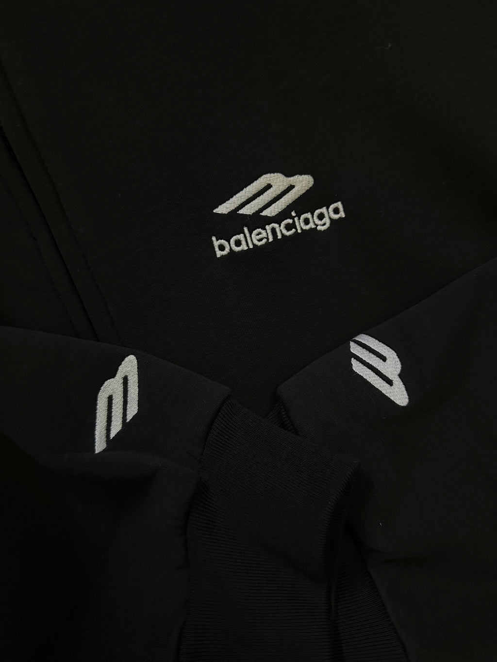 Black Balenciaga hoodie fabric with small white logo graphic and ribbed trim