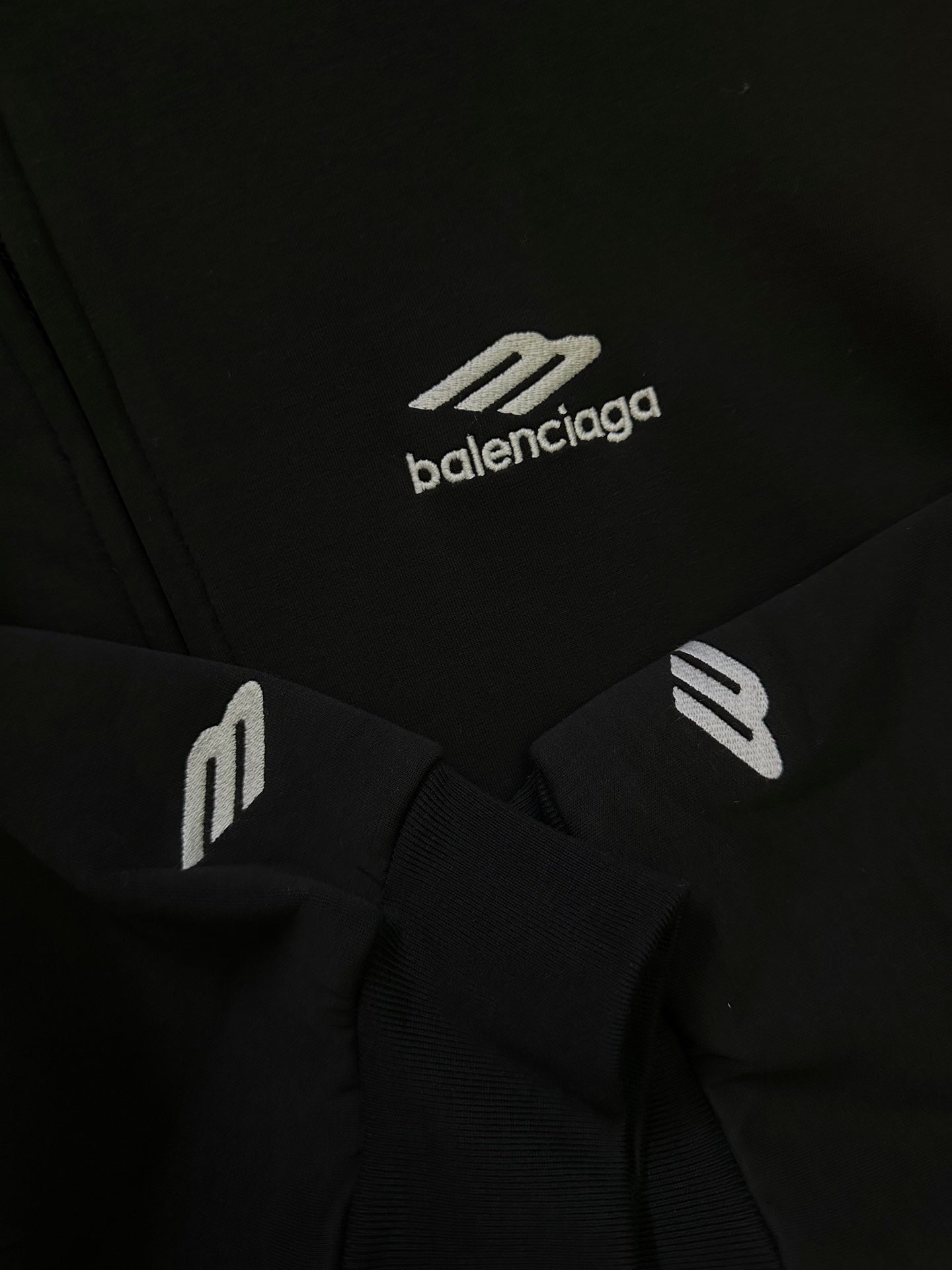 Black Balenciaga hoodie fabric with small white logo graphic and ribbed trim