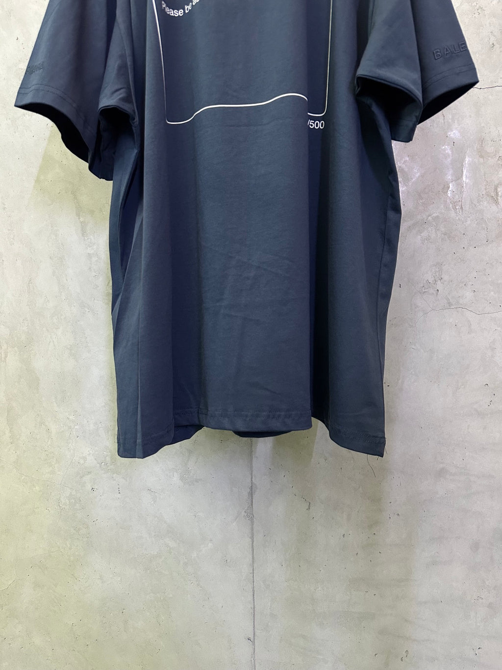 Dark blue short-sleeve T-shirt back view with slogan panel and curved hem