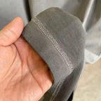Gray T-shirt hem cuff with stitched edge, held in hand
