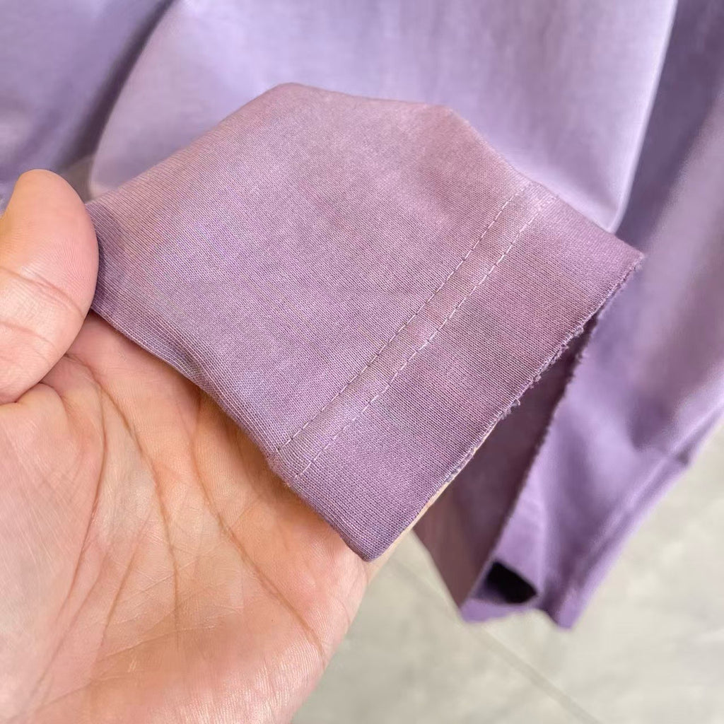 Lavender T-shirt sleeve cuff held in hand with stitched edge