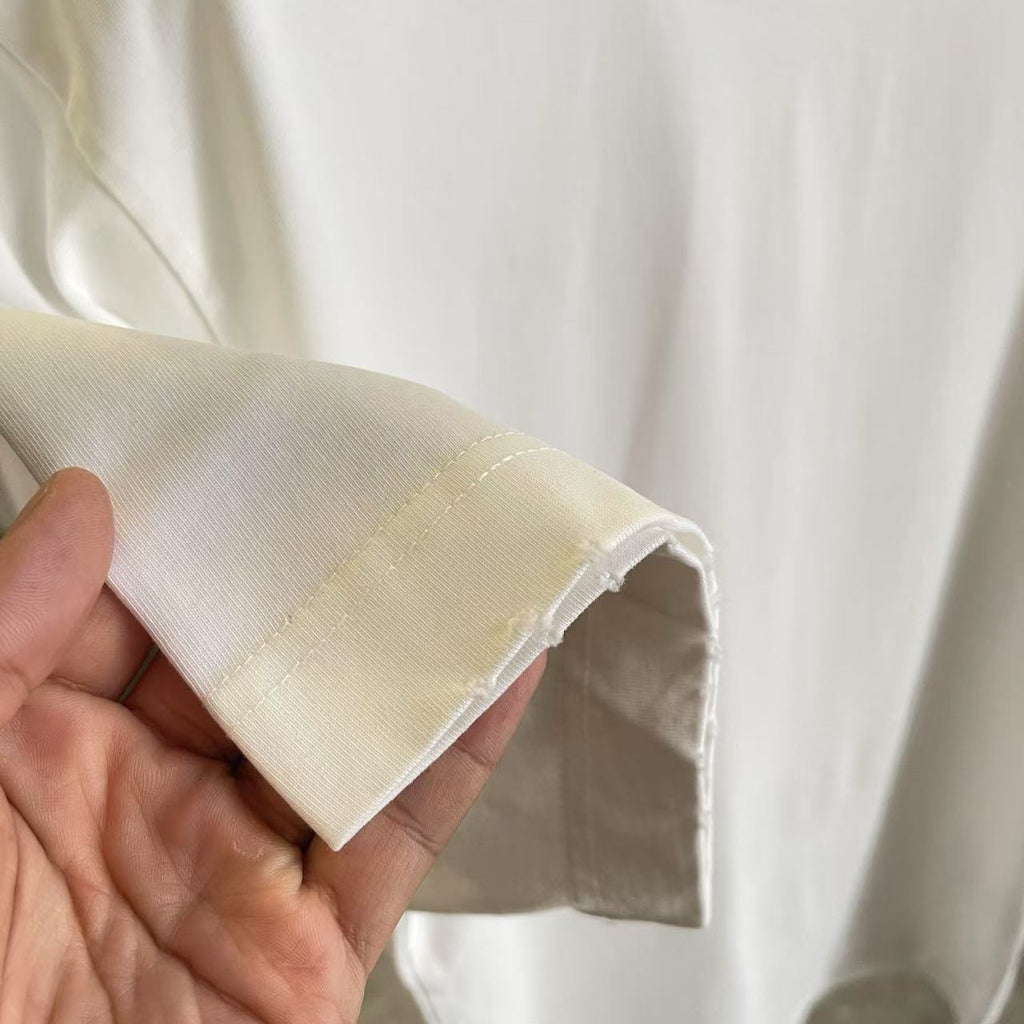 White T-shirt sleeve end with open stitching and reinforced hem