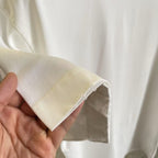 White T-shirt sleeve end with open stitching and reinforced hem