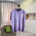 Lavender short-sleeve T-shirt with small pink cross graphic on the chest
