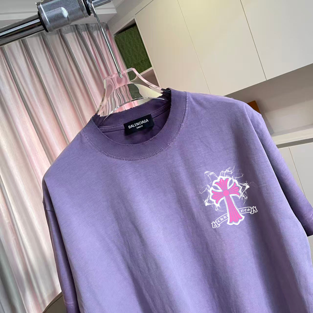 Lavender crewneck T-shirt with pink cross graphic and brand label at the collar