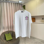 White short-sleeve T-shirt with small pink and black cross logo on the chest