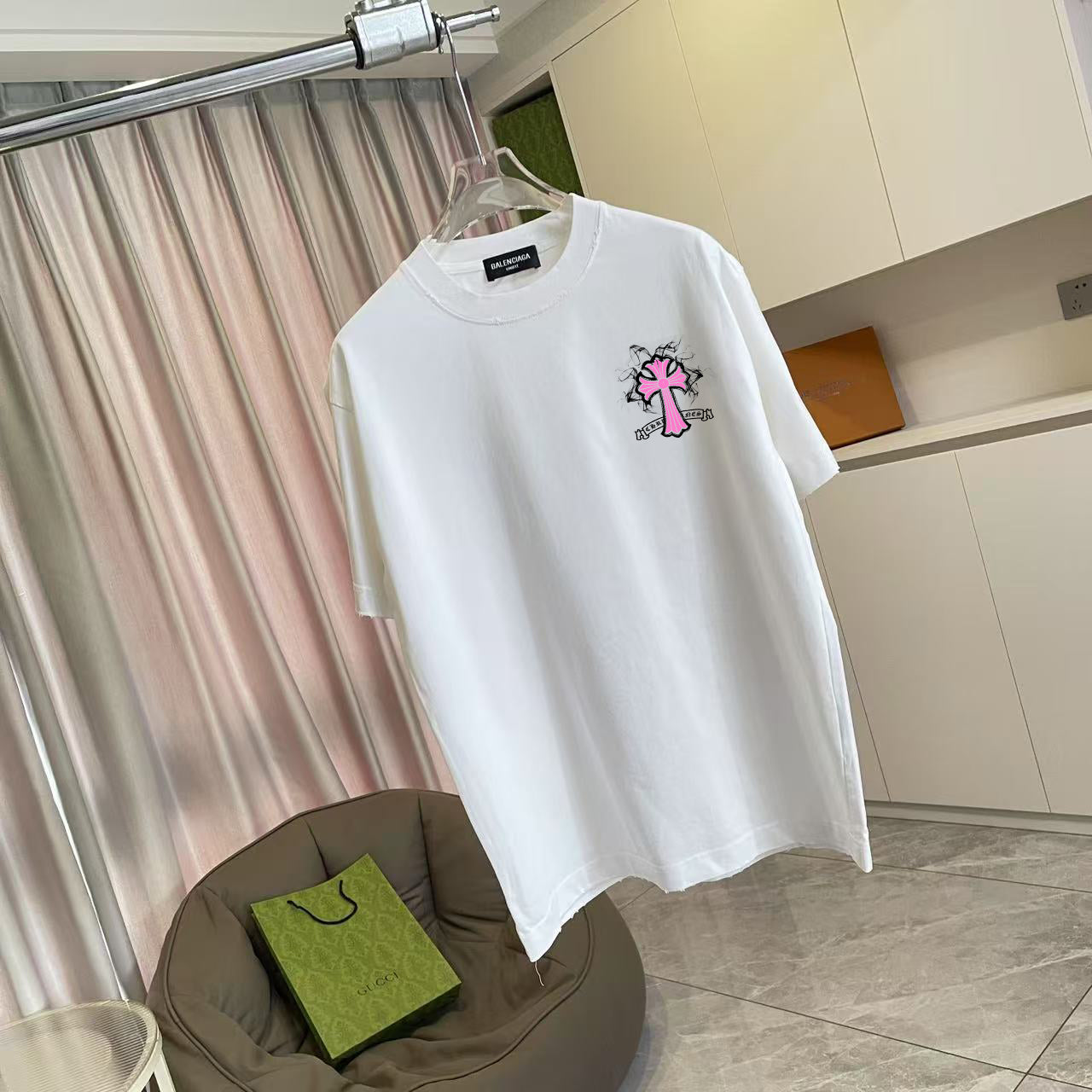 White short-sleeve T-shirt with pink and black cross logo, front view