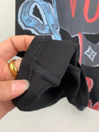 Louis Vuitton black T-shirt cuff detail with stitched fold and graphic print behind