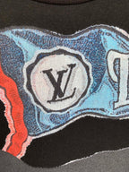Louis Vuitton graphic T-shirt close-up with LV logo medallion on blue background