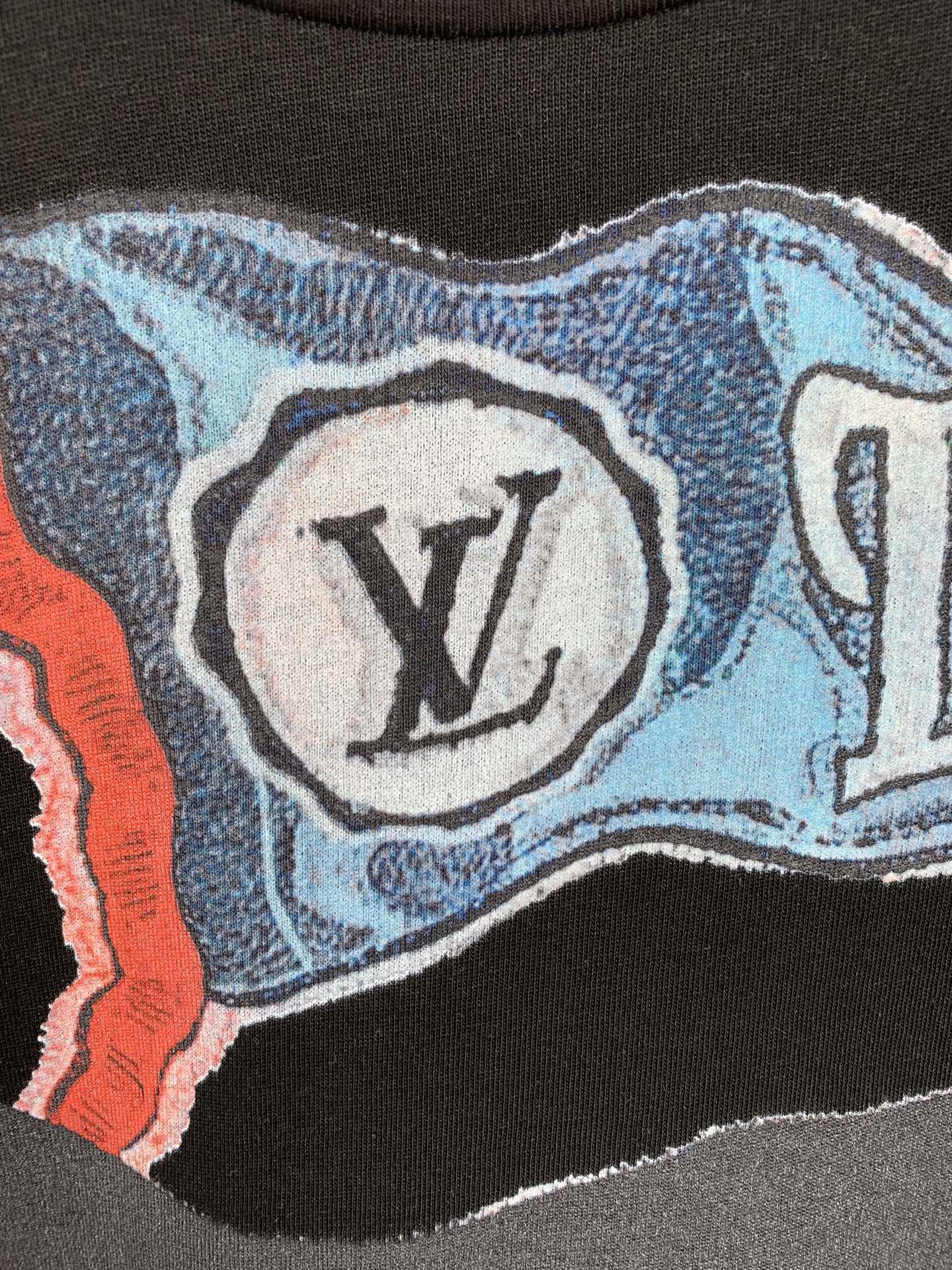 Louis Vuitton graphic T-shirt close-up with LV logo medallion on blue background