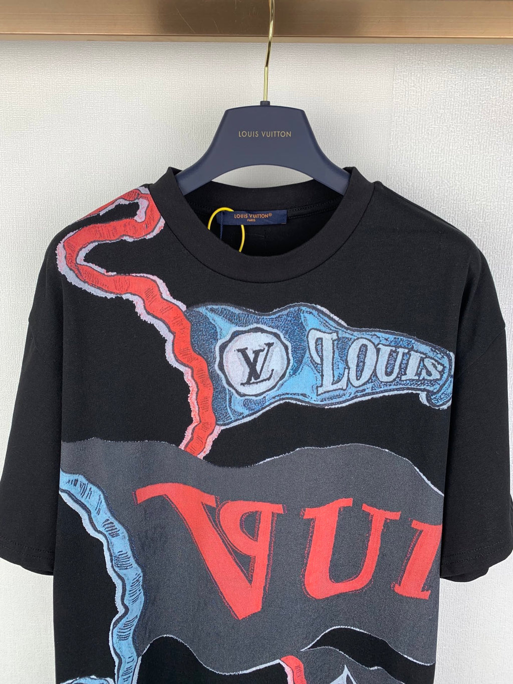 Louis Vuitton graphic T-shirt with black base, blue wave, and red lettering print