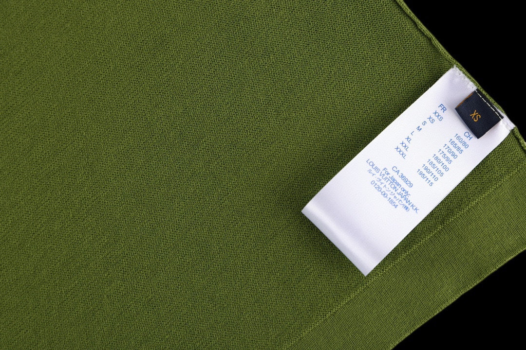 Green T-shirt close-up with stitched fabric and attached white care label