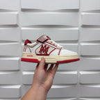 Amiri low-top sneakers with white uppers, red trim, and check-pattern strap