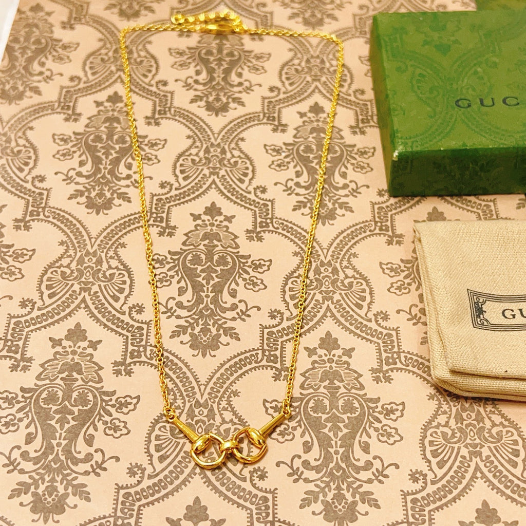 Gold-tone necklace with heart clasp and small link chain, shown flat