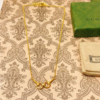 Gold-tone necklace with heart clasp and small link chain, shown flat