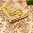 Gold-tone necklace with heart-link clasp and charm detail on patterned cloth