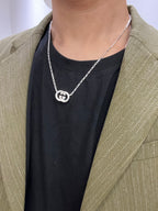 Gucci silver-tone GG pendant necklace worn with dark top and green blazer