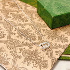 Gucci silver-tone GG pendant necklace with round emblem on patterned cloth