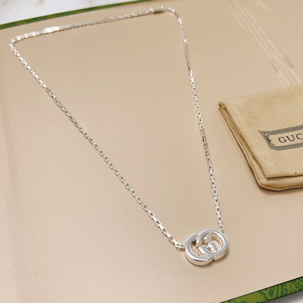 Gucci silver-tone pendant necklace with round GG emblem on display card