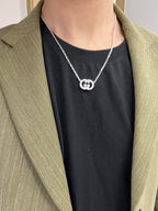 Gucci silver-tone pendant necklace with GG motif worn under blazer