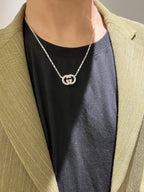 Gucci silver-tone GG pendant necklace worn with black top and light blazer