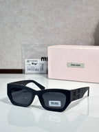Black oversized sunglasses with dark tinted lenses and gold logo on side temples