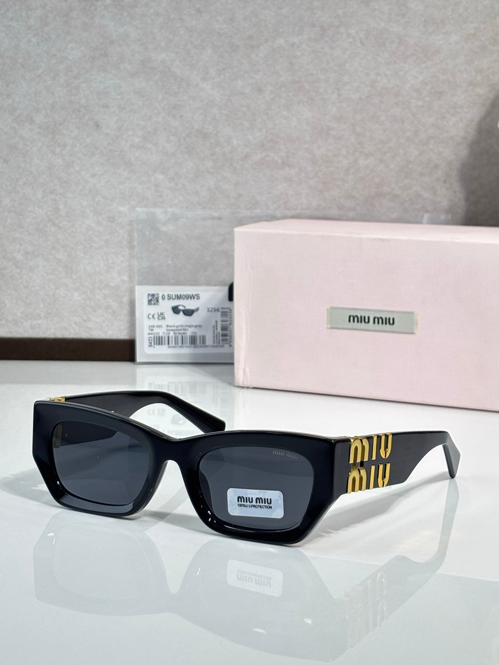 Black oversized sunglasses with dark tinted lenses and gold accent on side temples