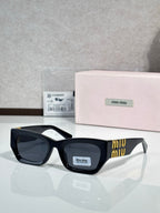 Black oversized sunglasses with dark tinted lenses and gold accent on side temples
