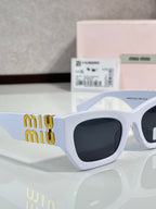 Light blue oversized sunglasses with dark tinted lenses and gold miu miu logo