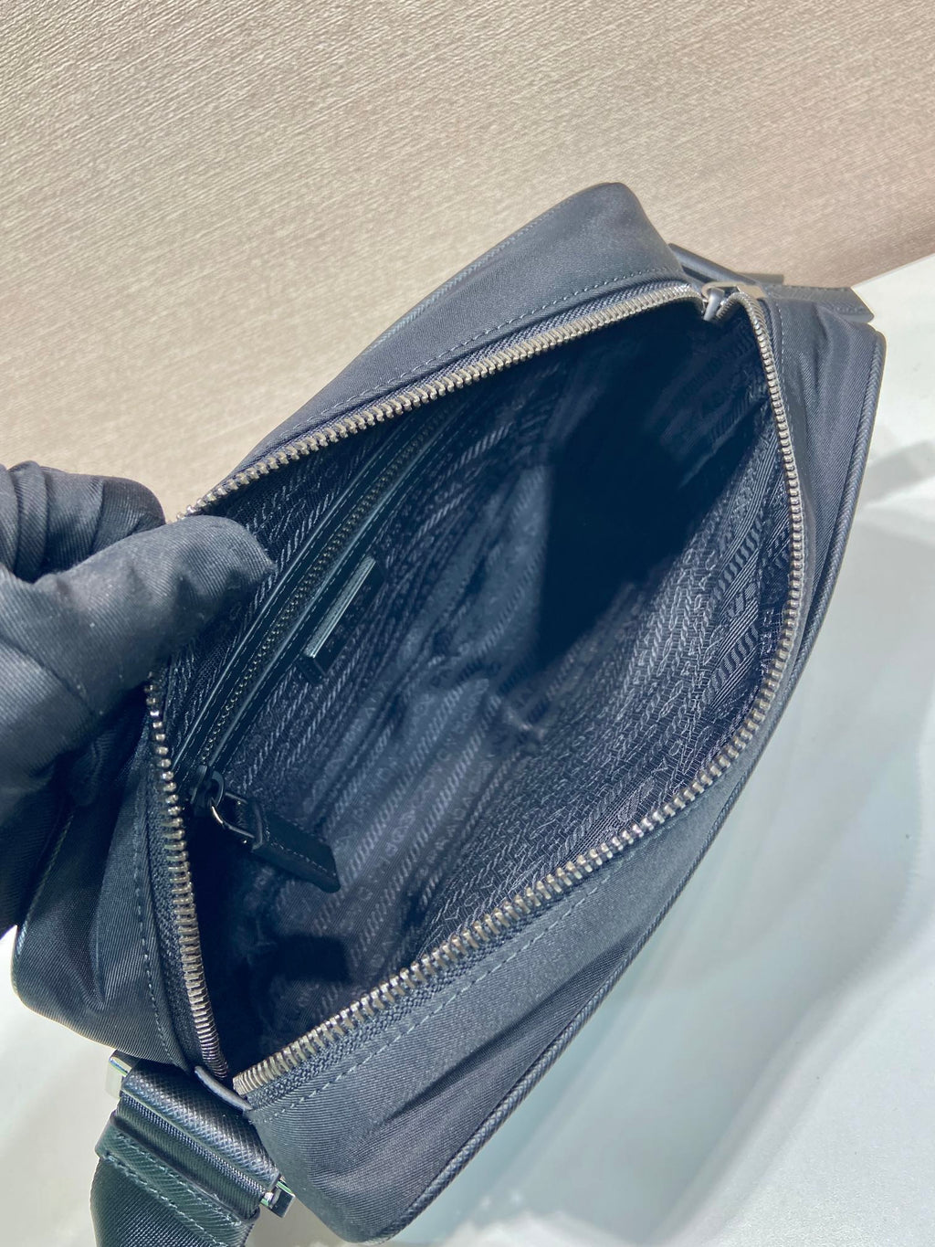 Prada bag open top view showing inner fabric and zipper lining, dark blue