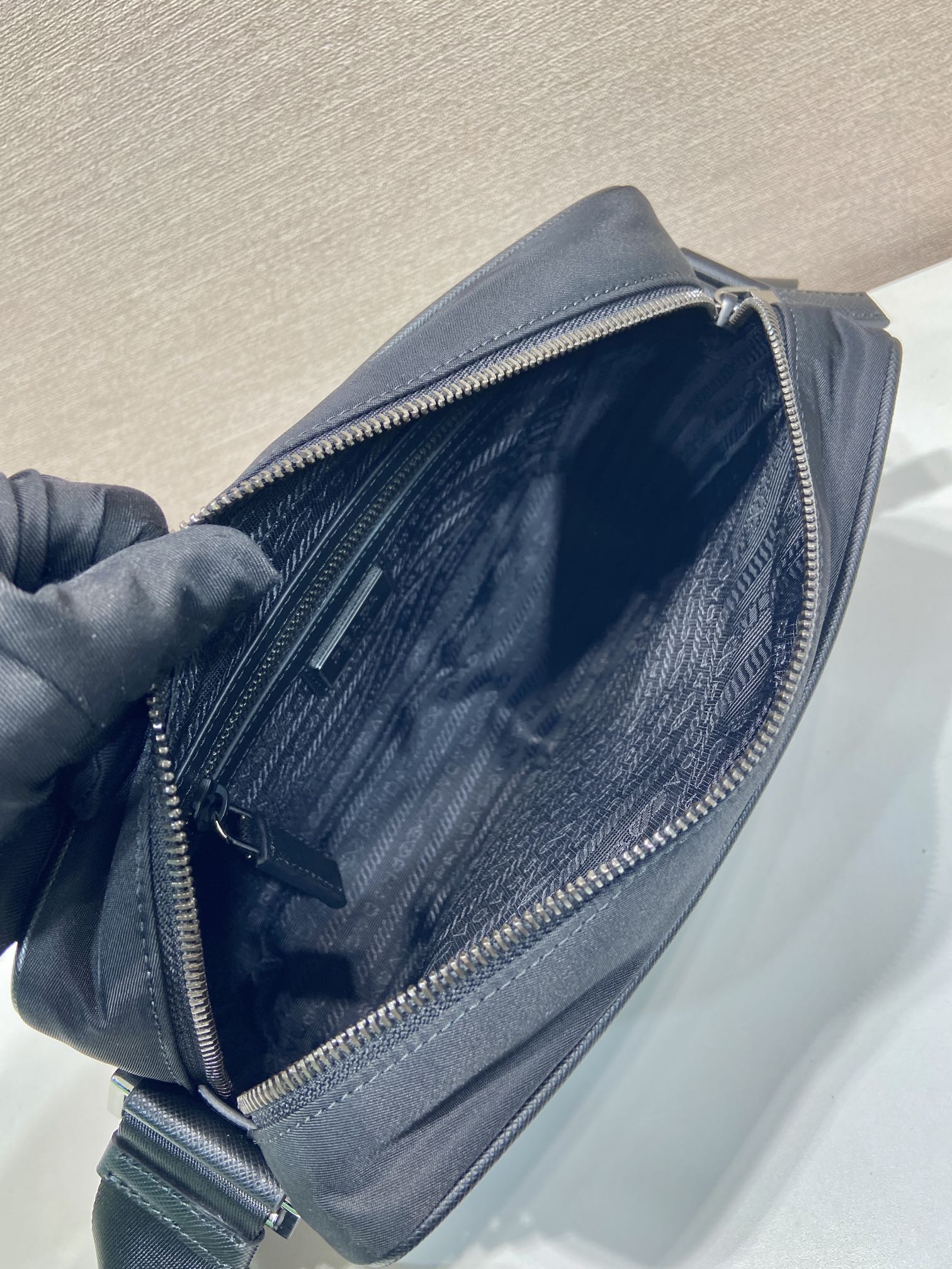 Prada bag open top view showing inner fabric and zipper lining, dark blue