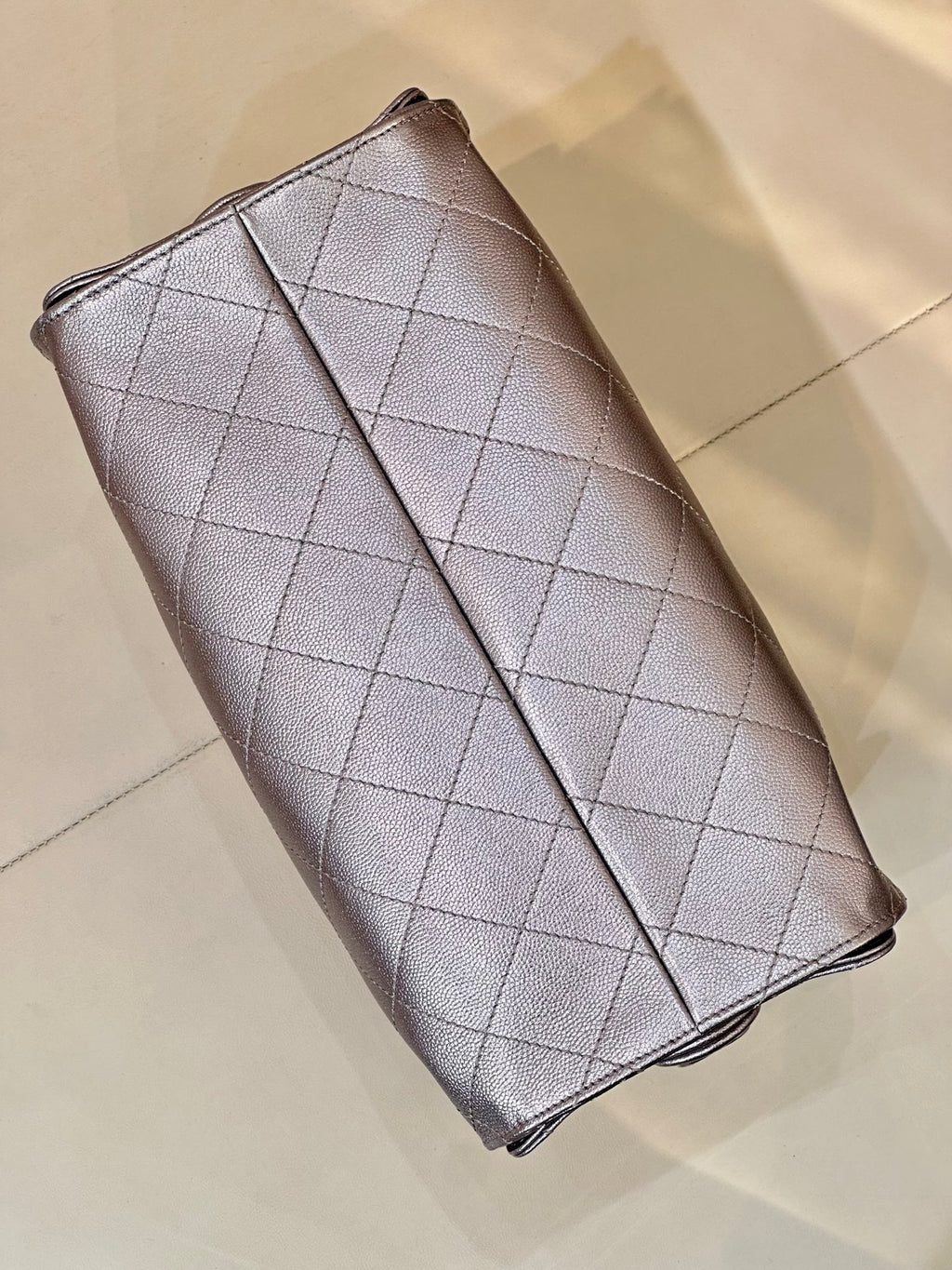 Quilted leather flap wallet on chain with Chanel CC emblem, silver tone, angled view