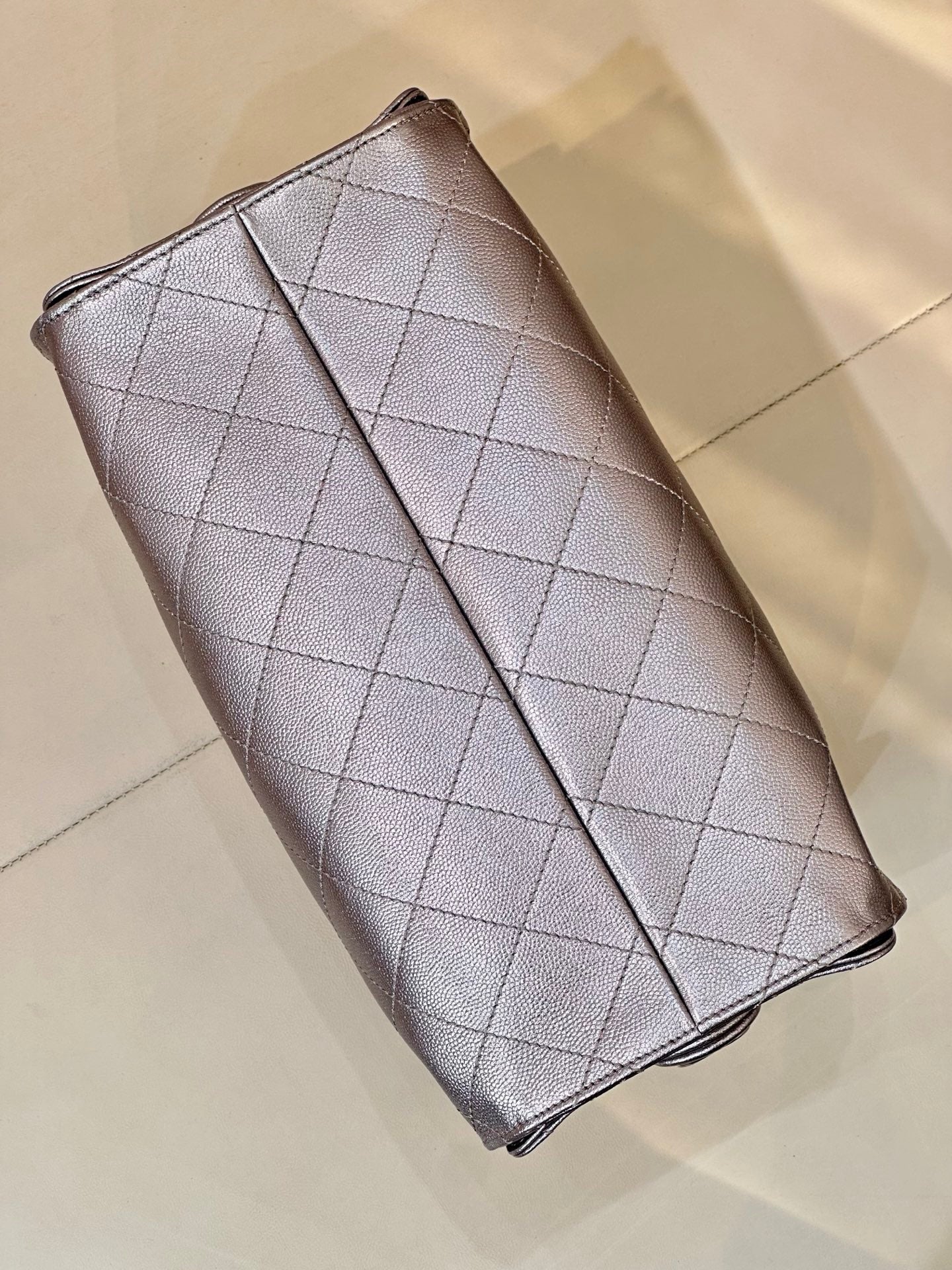 Quilted leather flap wallet on chain with Chanel CC emblem, silver tone, angled view