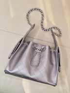 Quilted leather tote bag with chain handles, side tassels, and Chanel logo on front, silver