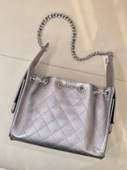 Quilted leather shoulder bag with chain handles and Chanel CC charm on front, silver tone