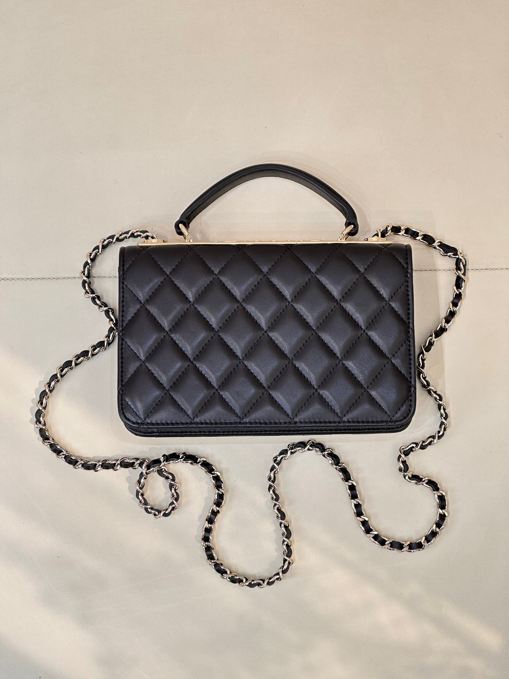 Dark navy quilted Chanel handbag with top handle and chain strap, front centered