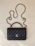 Dark navy quilted handbag with top handle, chain strap, and Chanel logo front