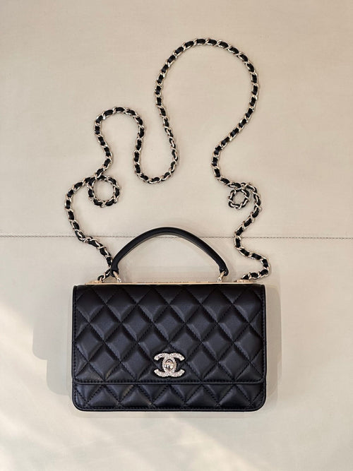Dark navy quilted handbag with top handle, chain strap, and Chanel logo front