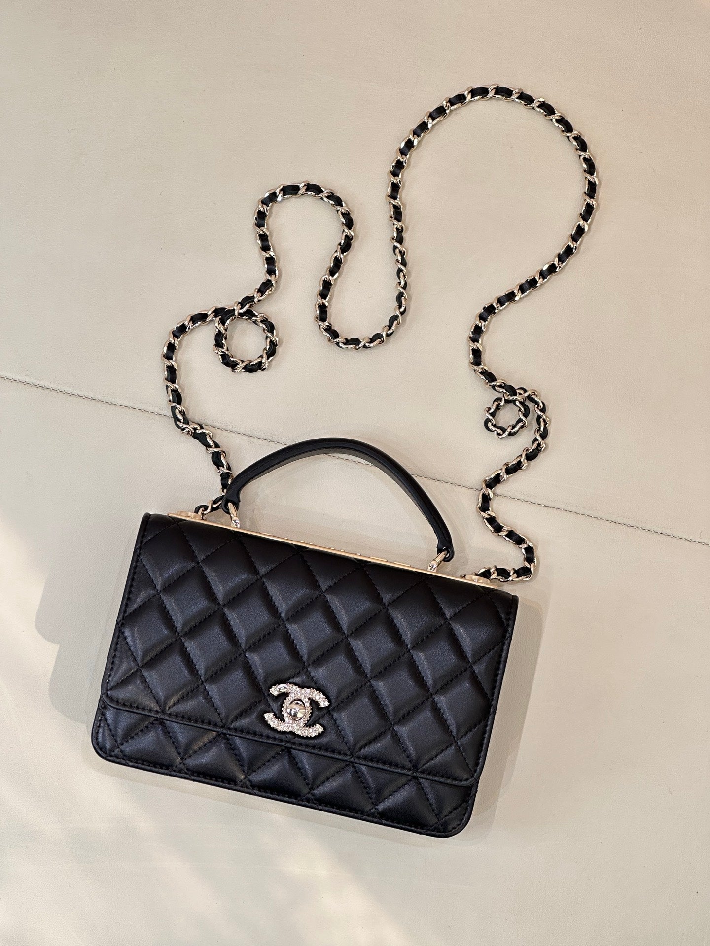 Dark navy quilted Chanel handbag with chain strap and top handle, front view
