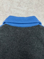 Knit vest collar detail with blue ribbed trim on dark gray body