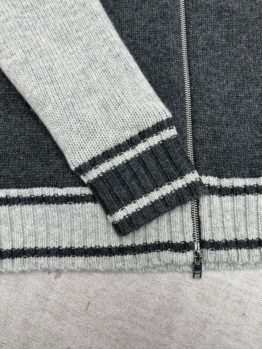 Sleeve cuff and hem stripes on a knit vest with ribbed dark trim and light cuffs