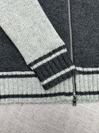 Sleeve cuff and hem stripes on a knit vest with ribbed dark trim and light cuffs