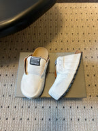 Balenciaga white slide sandals, one showing the side and toe profile