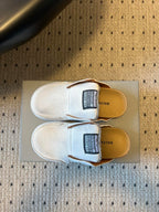 Balenciaga white slide sandals with black size label and tan footbed