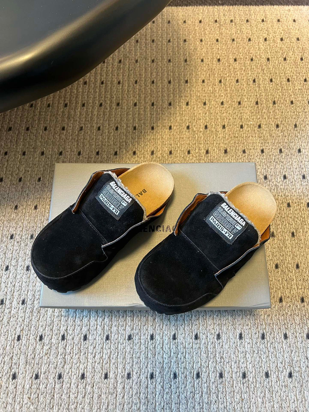 Pair of black suede slide sandals with branded logo patch straps