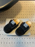 Pair of black suede slide sandals with branded logo patch straps