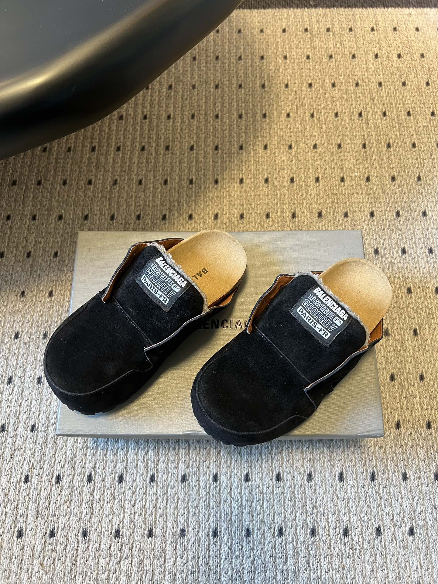 Pair of black suede slide sandals with branded logo patch straps