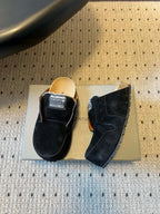 Black suede slide sandals, showing front and side views with logo patch